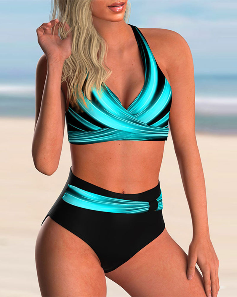Woman in a stylish printed bikini set standing against a beach background.