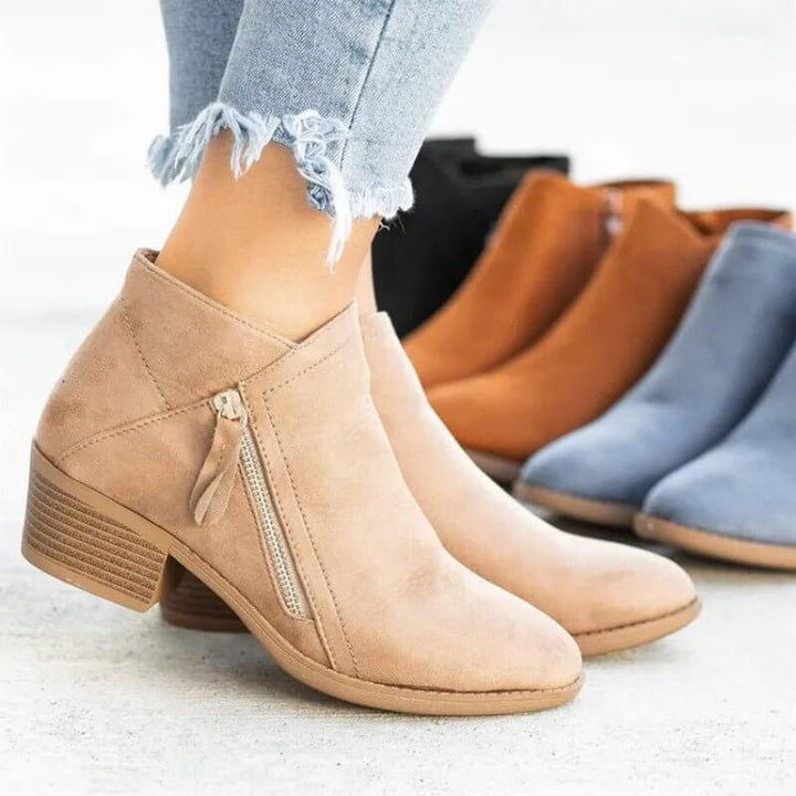 Tan ankle boot with zipper on a light background