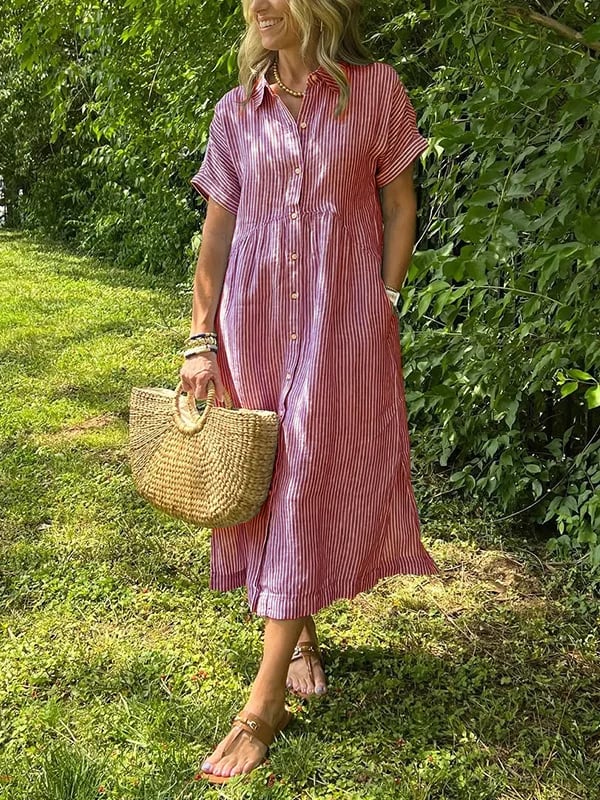  Female wearing a striped shirt dress style garment on a plain background.