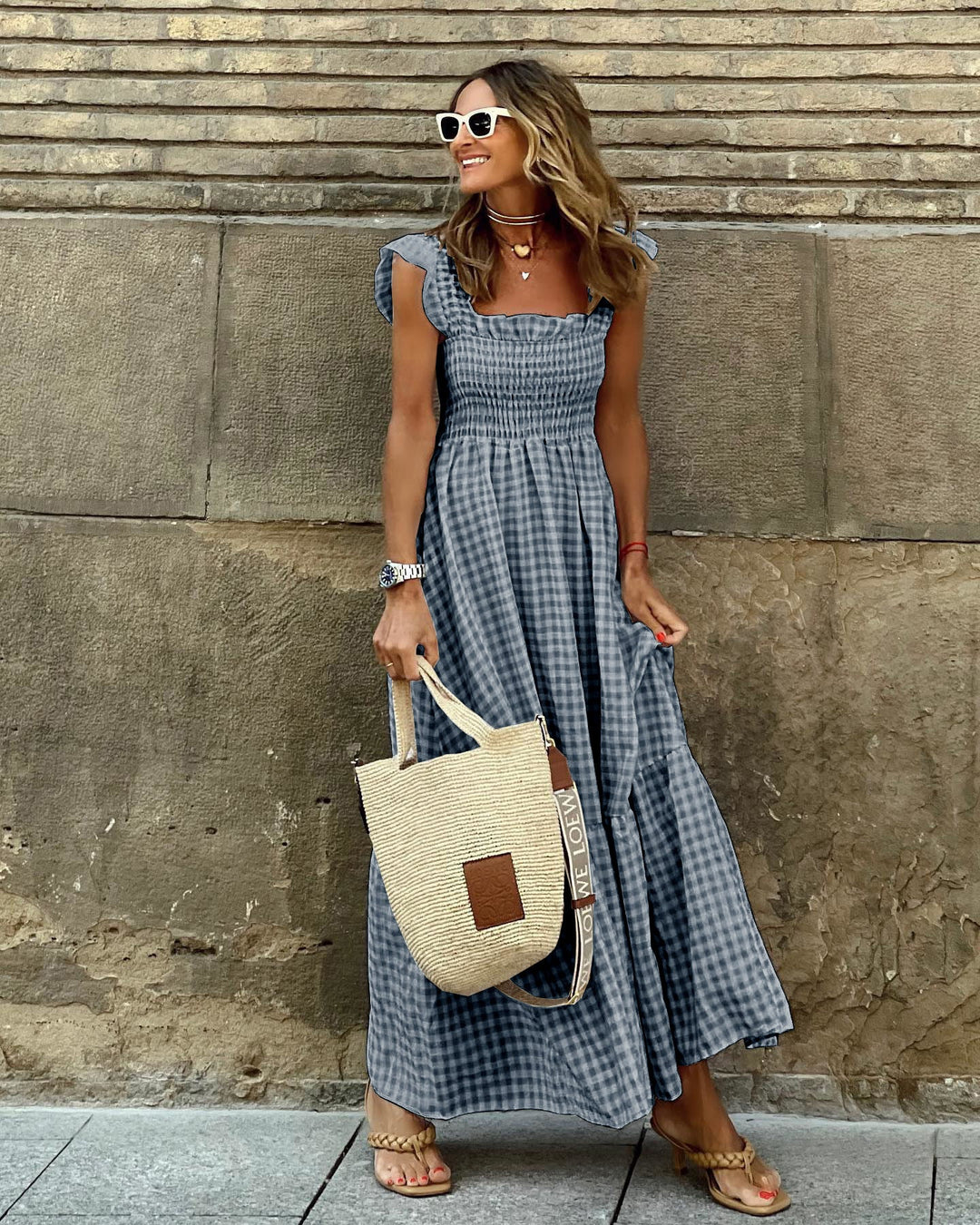 Woman model in a relaxed flowy gingham maxi dress with smocked bodice.