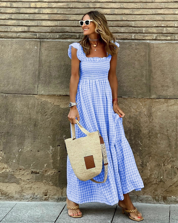 Model wearing a summer gingham maxi dress with tiered design.