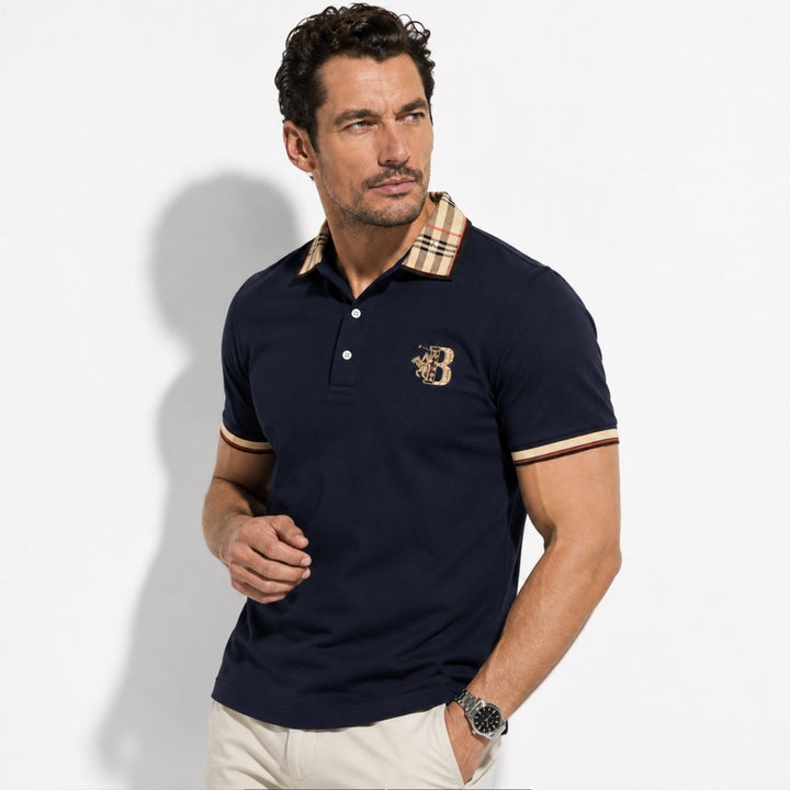 Model wearing a navy short sleeve polo shirt with check collar on a plain background.