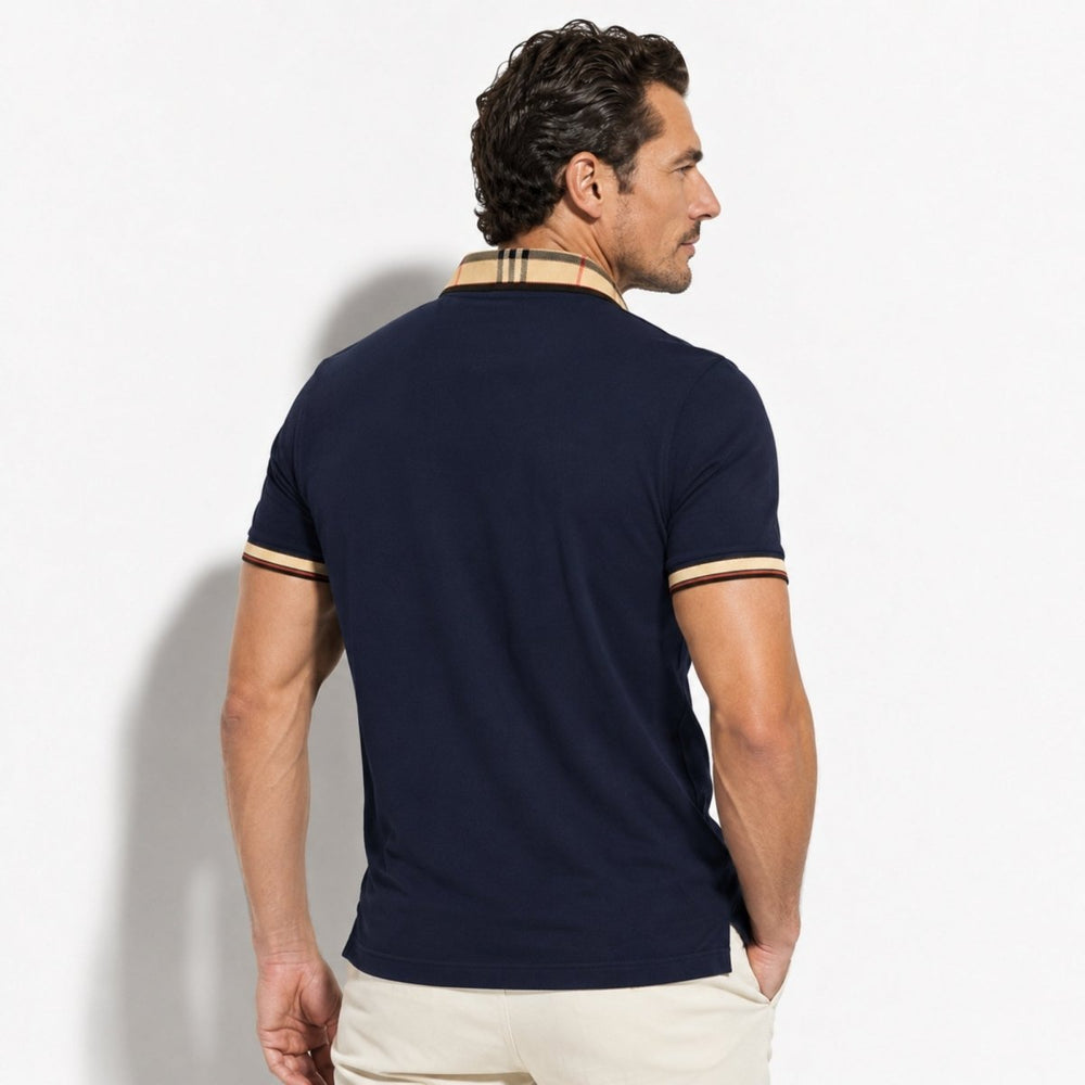  Model styled in a men’s navy polo shirt with contrast check trim on a plain background.