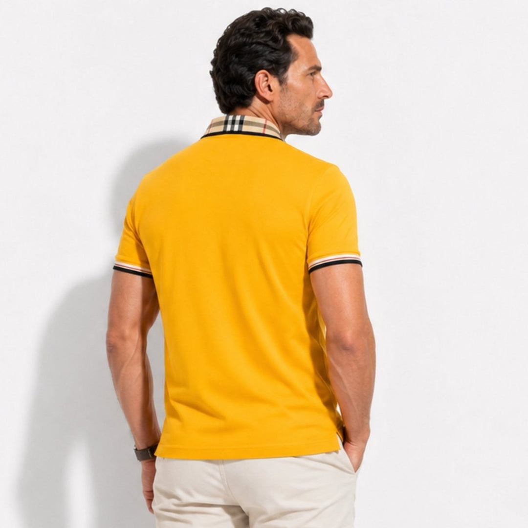 Model wearing a smart casual polo shirt with check collar and sleeve details on a plain background.