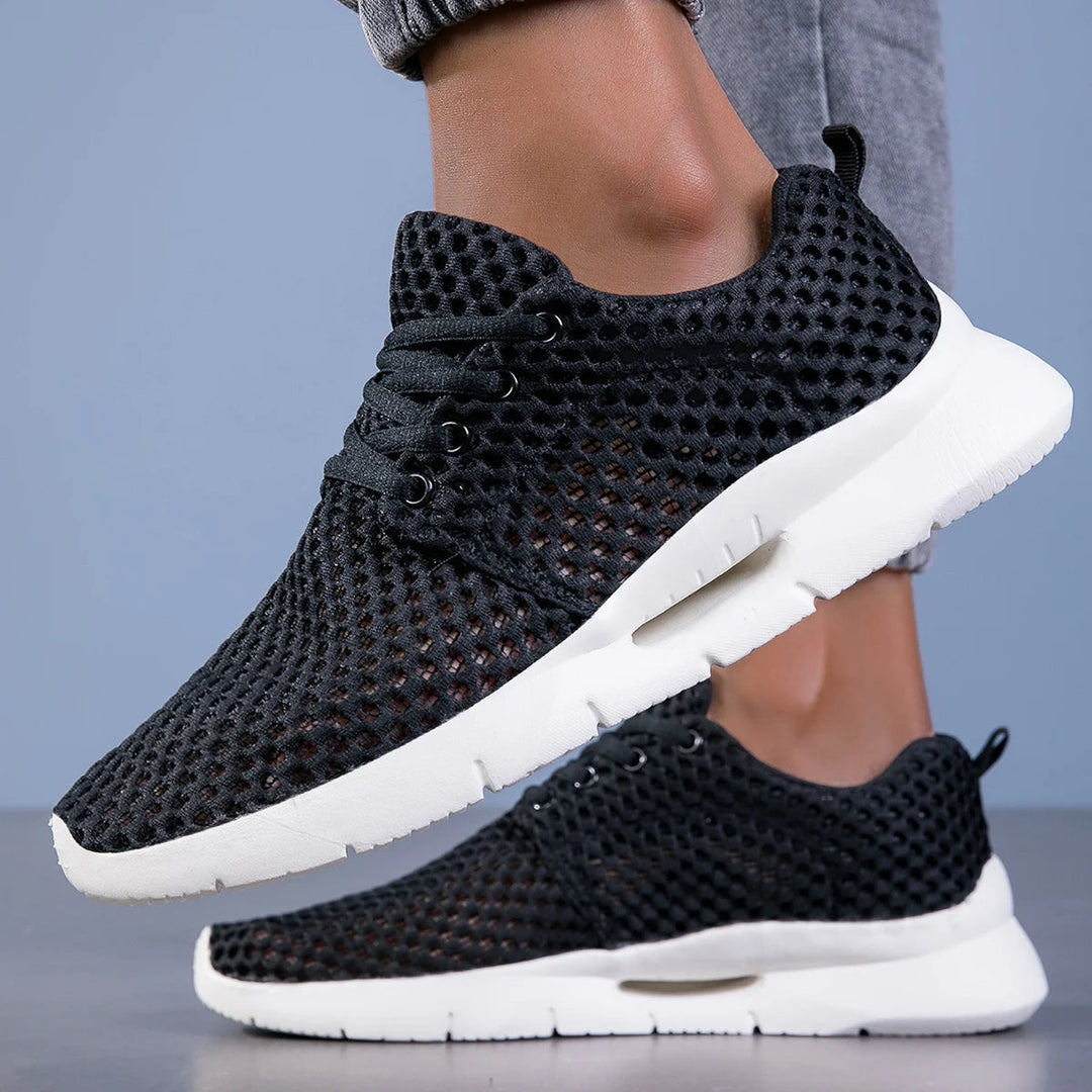 Close view of breathable black sneakers indoors