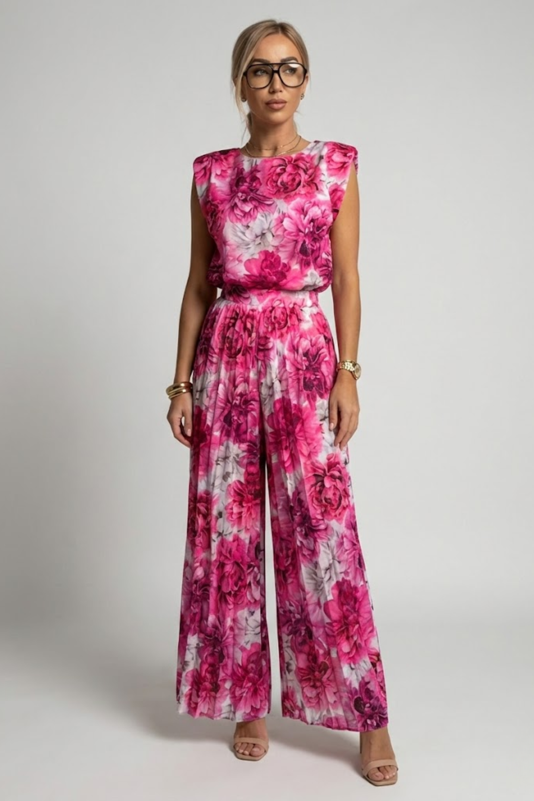 Female dressed in a stylish vacation-ready matching set on a plain background.