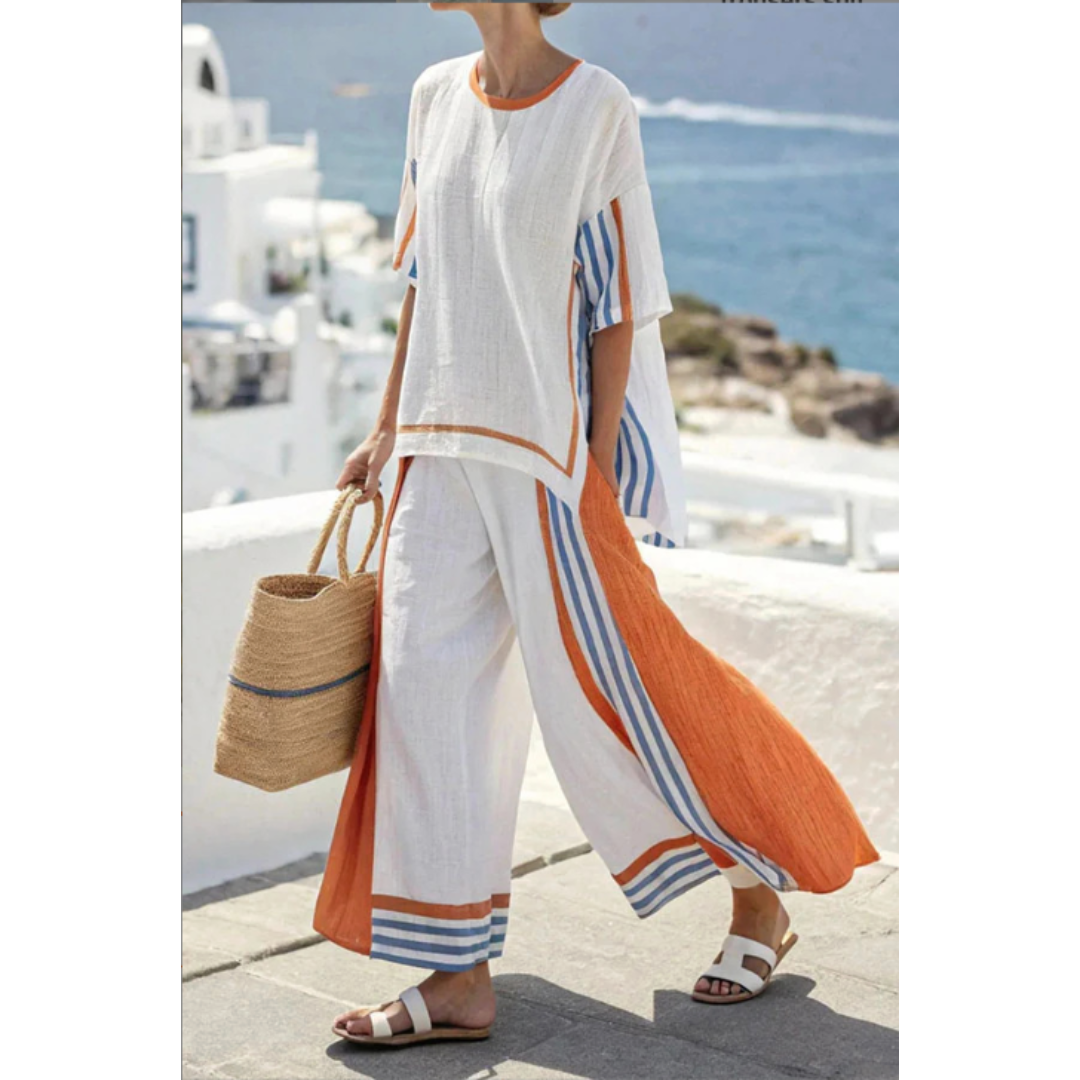 Female model wearing a chic matching top and pants set on a clean beach background.