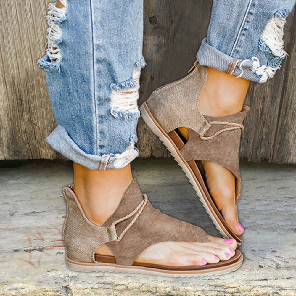 Foot model standing naturally in sandals on soft beige background.
