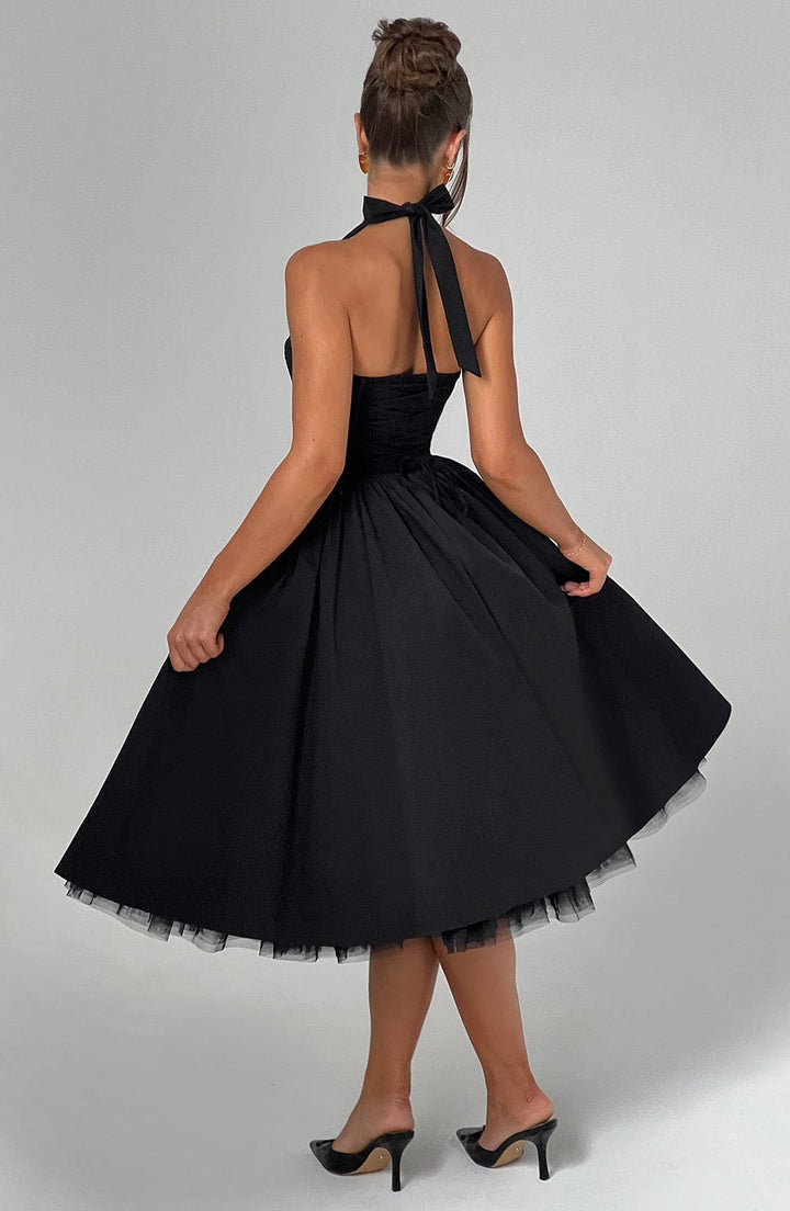 Female model showing dress movement on gray plain studio background, back view
