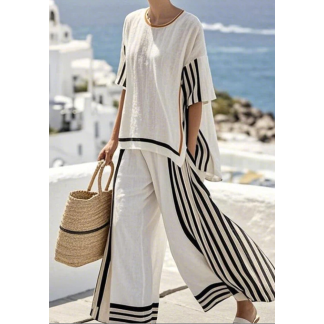 Woman wearing a striped matching set with a flowing skirt against a plain background