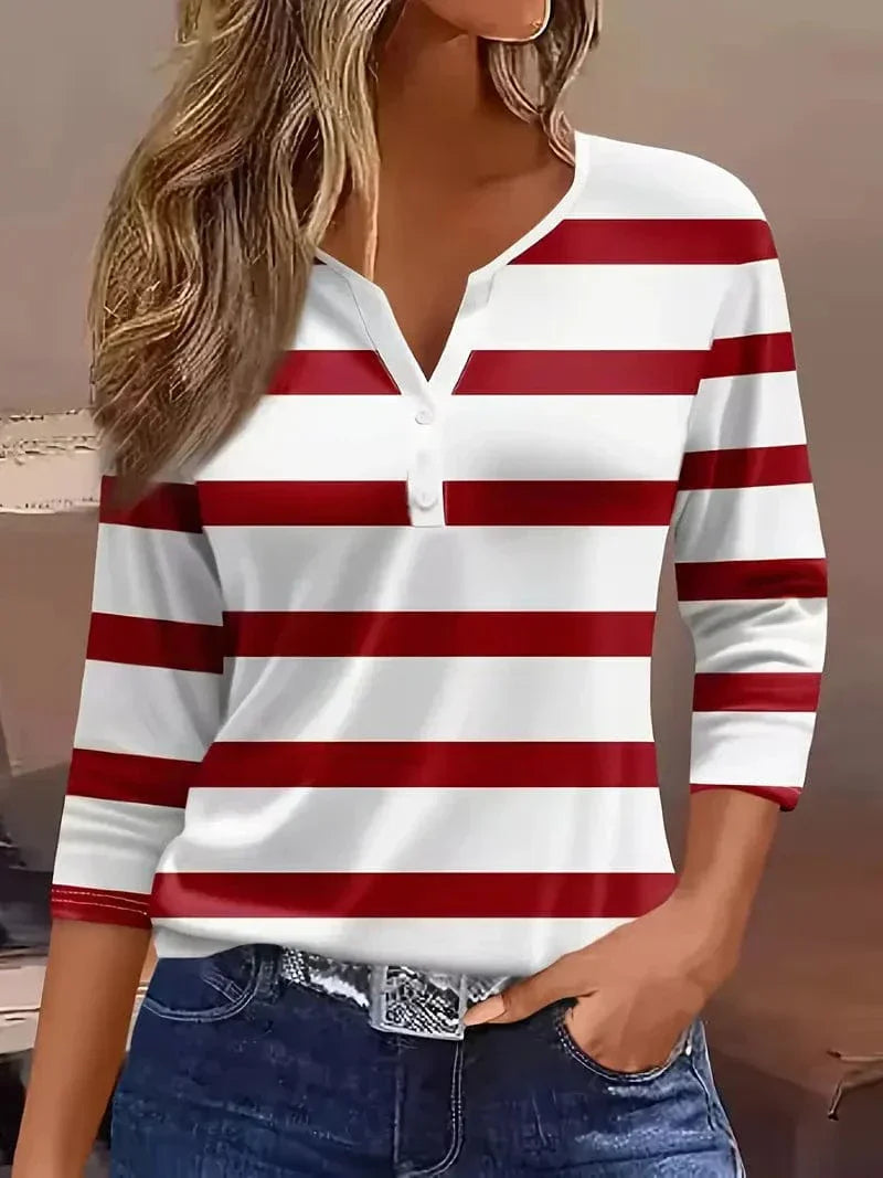 Woman wearing a striped ¾ sleeve top against a plain background.