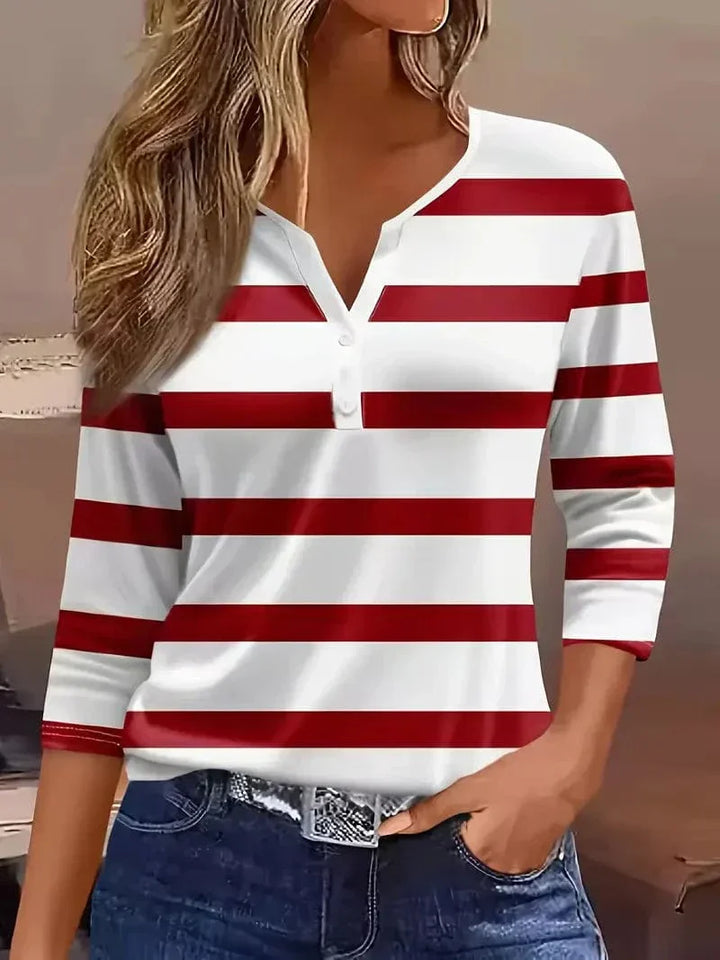 Woman wearing a striped ¾ sleeve top against a plain background.