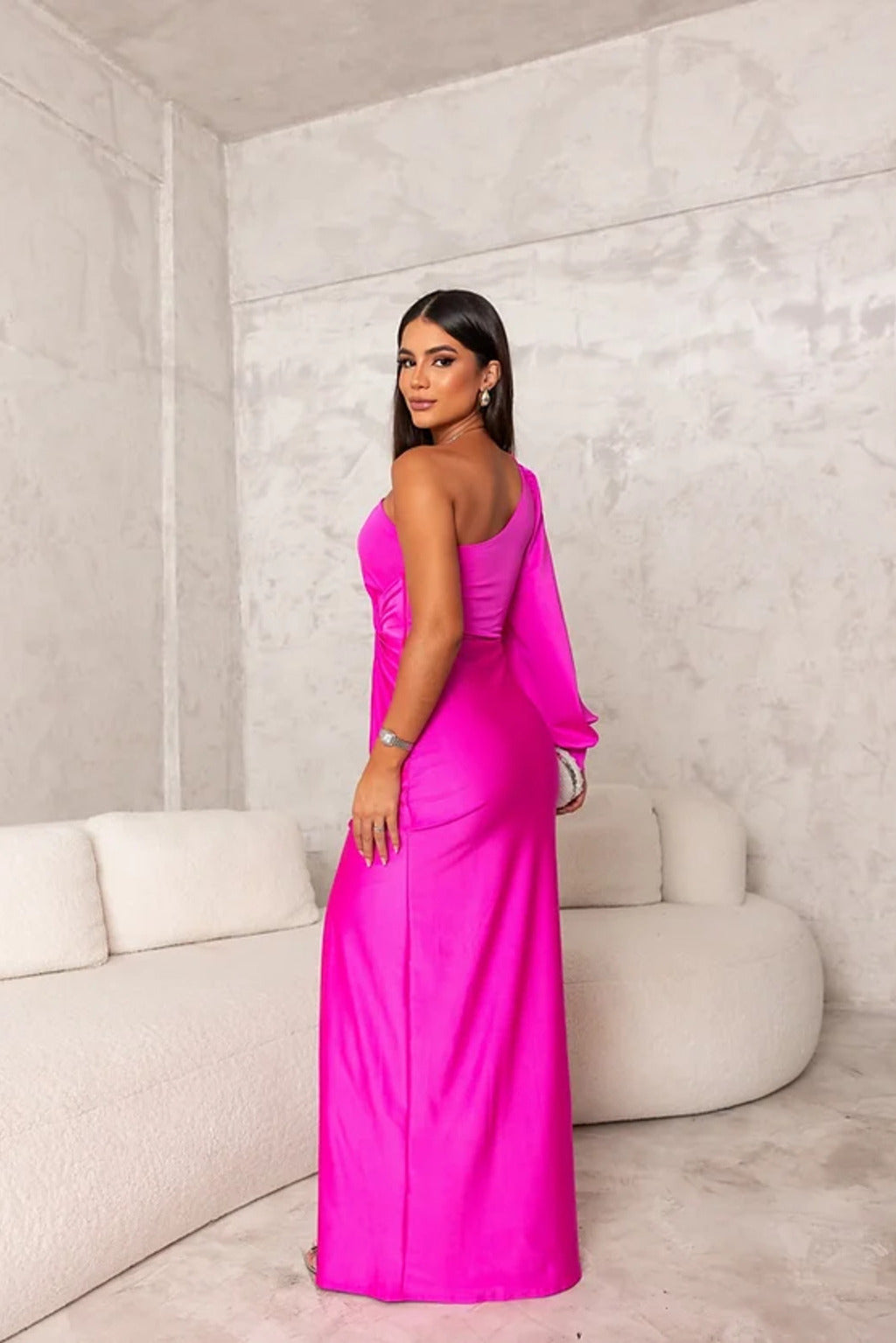  Female model in a contemporary evening gown with an eye-catching silhouette on a plain background.