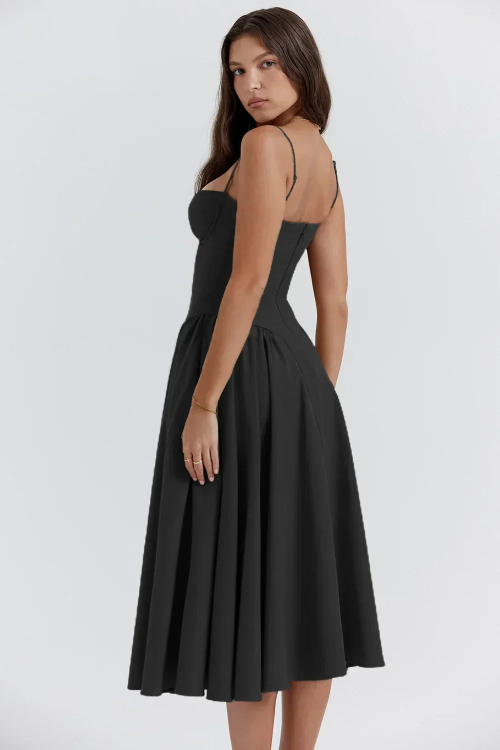 Female wearing an airy midi dress with soft movement on a plain background