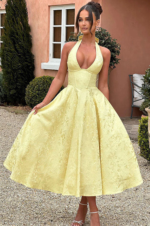 Elegant halterneck dress with defined waist and full skirt.