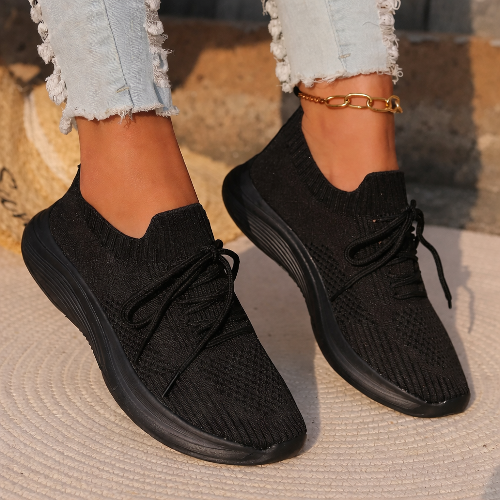 Black sneakers and gold anklet close-up