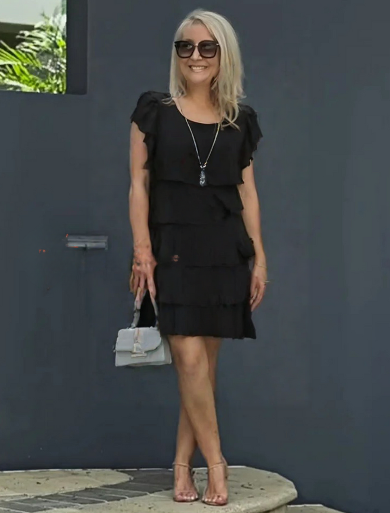 Female model wearing a polished midi dress with short sleeves on a plain background.