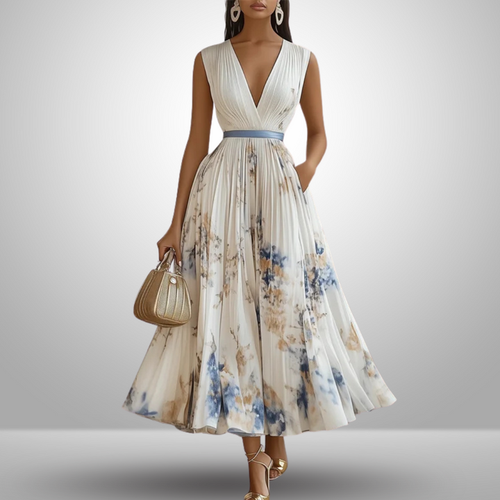 Woman wearing a graceful pleated warm-weather outfit on a plain background.