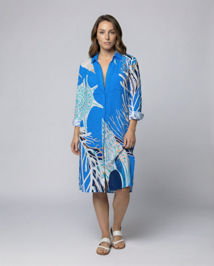 Female model wearing a long beach blouse with an ocean-inspired print against a plain background.