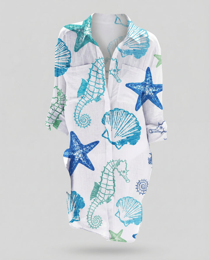 Female model wearing a long beach blouse with a flowing fit and marine-inspired artwork.