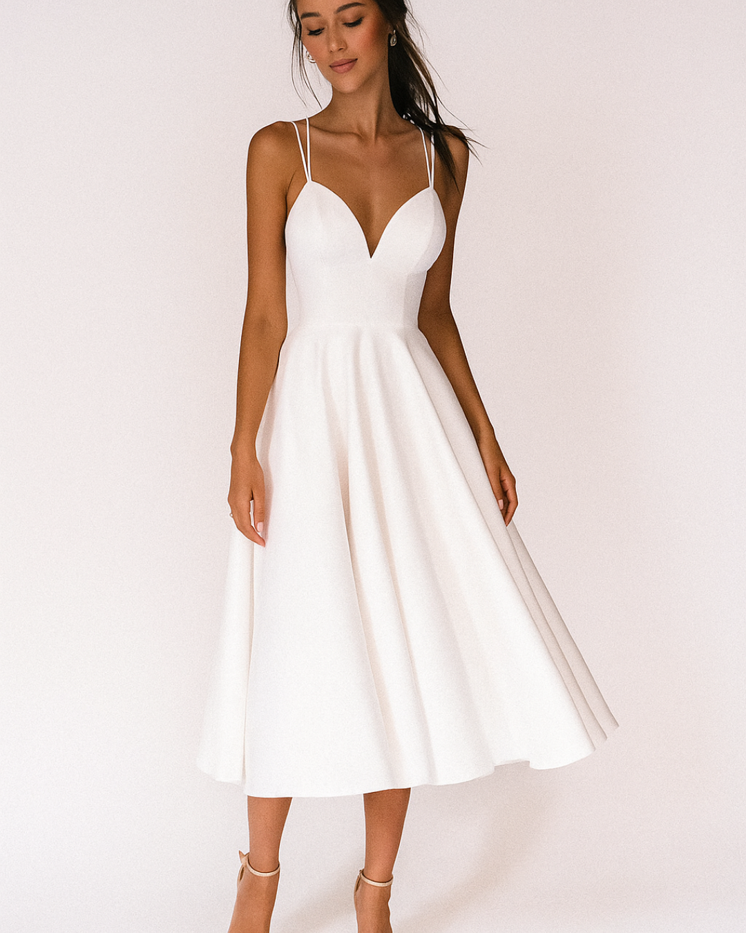 Female model wearing strappy midi dress posing front beige background