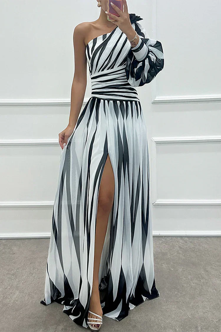 Woman wearing a striped one-shoulder dress against a plain background.