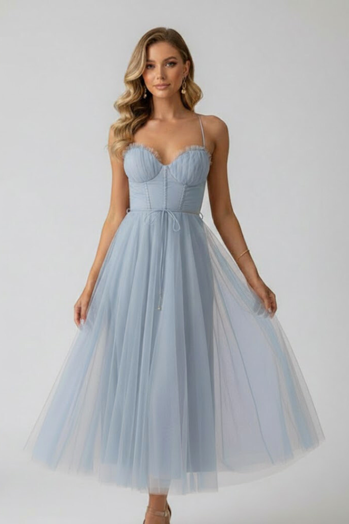 Female model showing sleeveless dress design on plain gray background.
