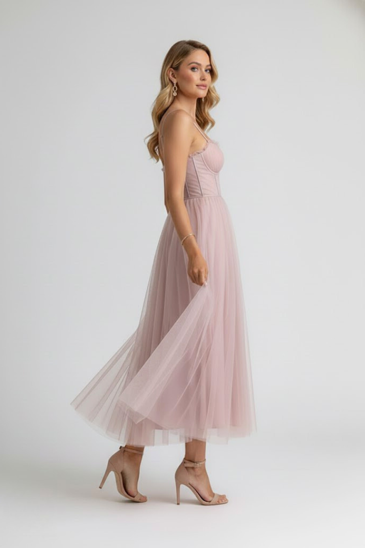 Female model in sweetheart neckline dress on plain gray background.