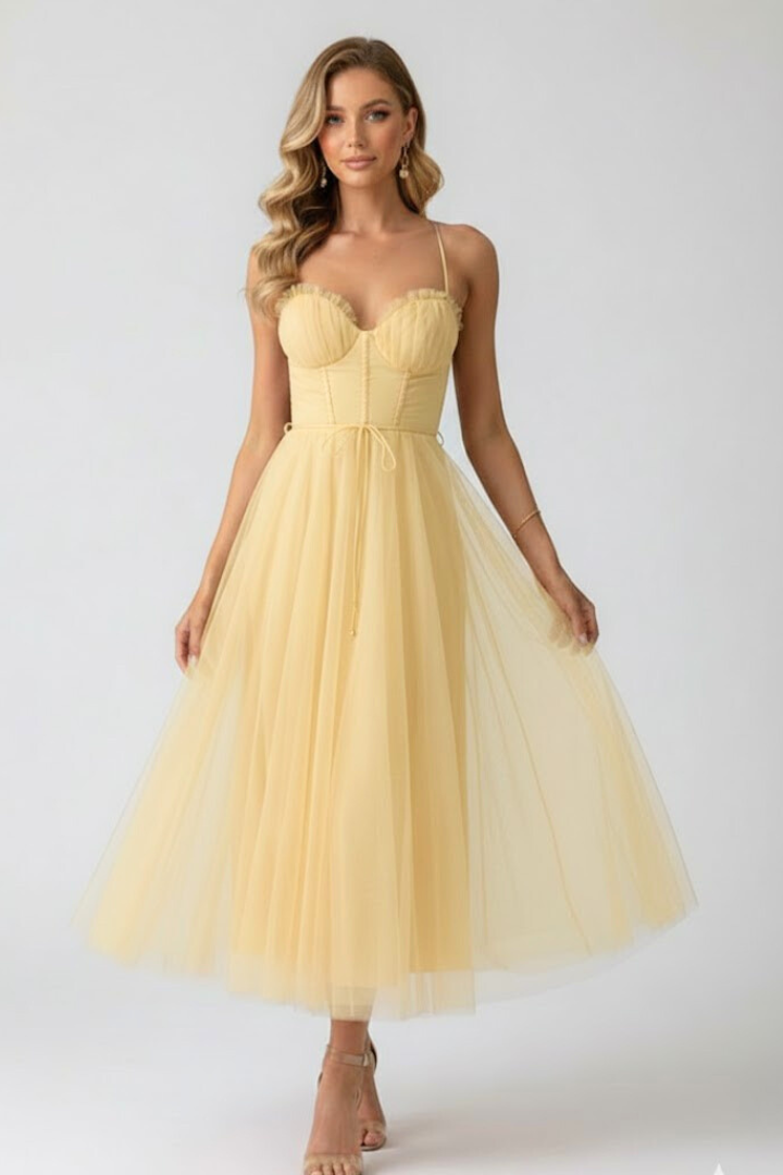 Female model in formal tulle outfit on plain gray background.
