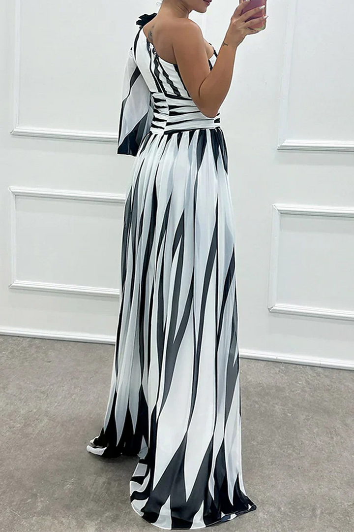 Female model showing a flowing striped dress against a plain background.