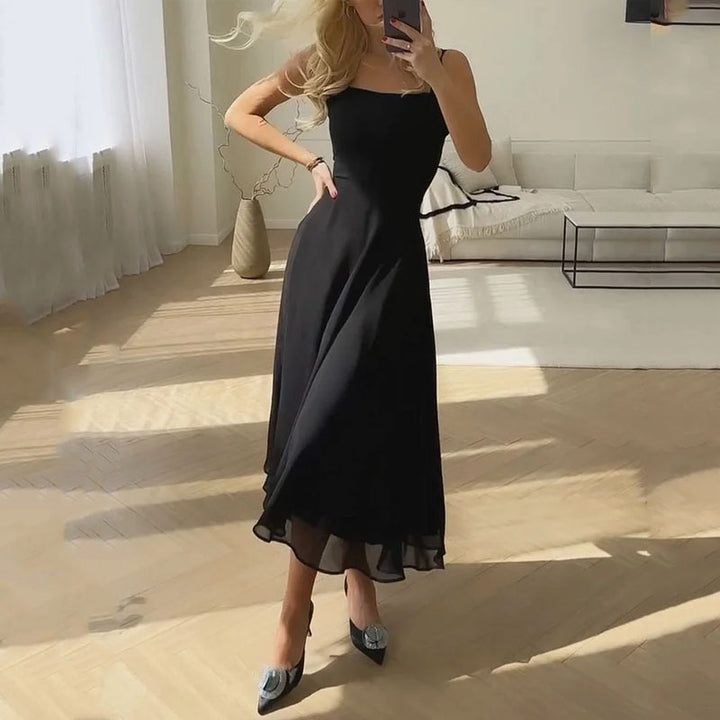 Woman standing front square neckline dress living space soft neutral tones