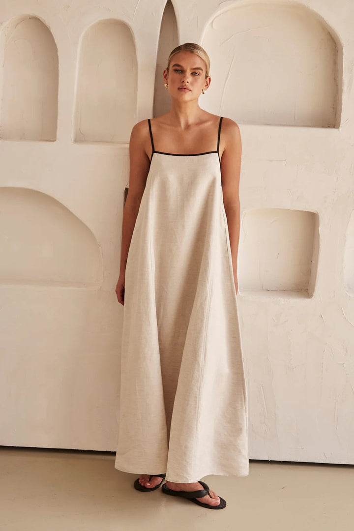 Woman posing elegant stance wearing maxi dress plain background shot