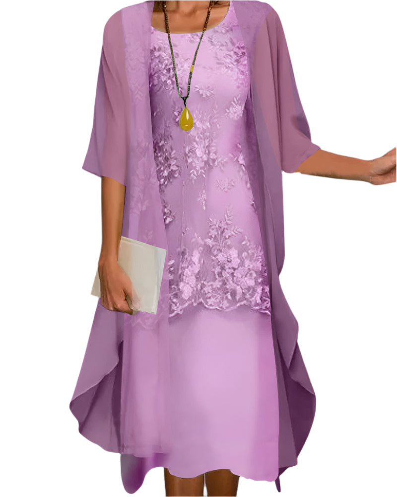 Woman posing full length in midi dress on plain gray background.