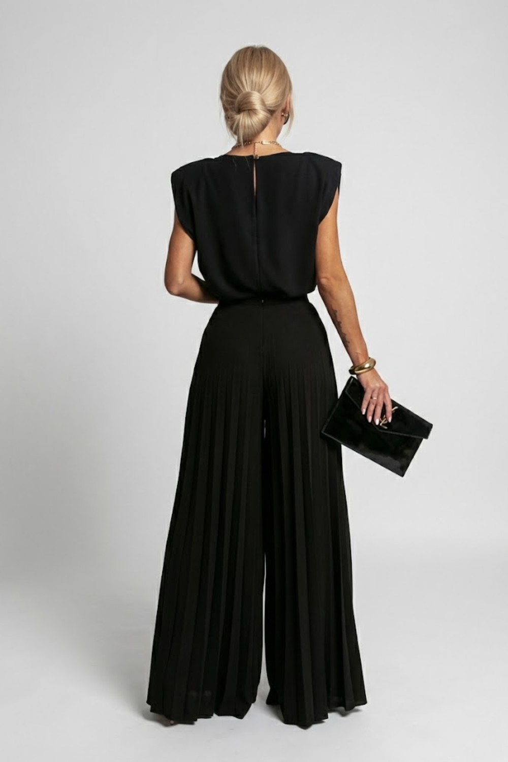 Woman styled in a relaxed matching set with wide-leg pants on a plain background.