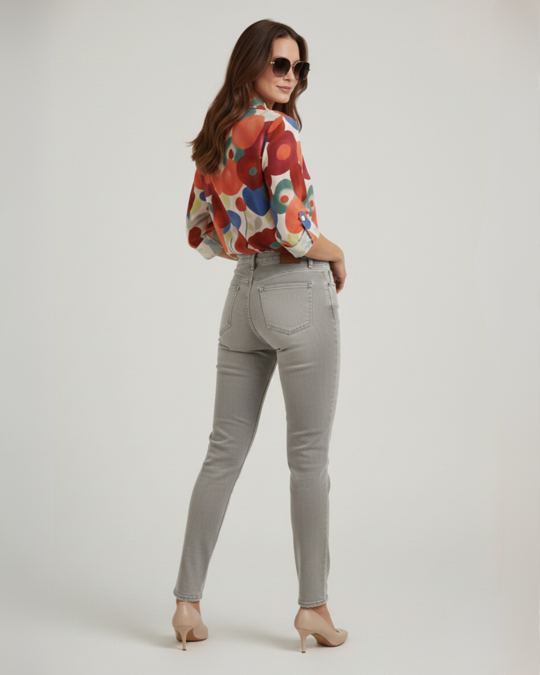 Model in full view of vibrant floral summer top ad jeans