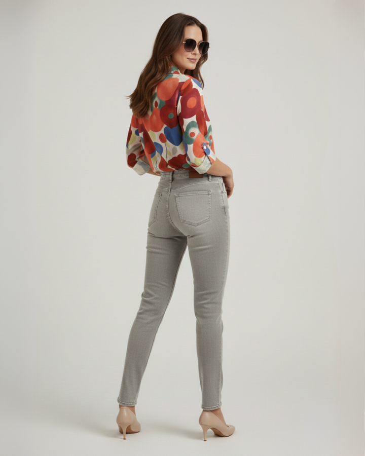 Model in full view of vibrant floral summer top ad jeans