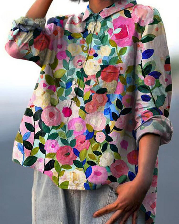 Woman model wearing a floral button front pocket blouse against a plain background.