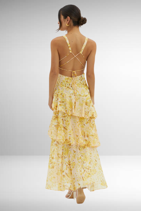 Model posing gently in floral maxi plain background, back angle view