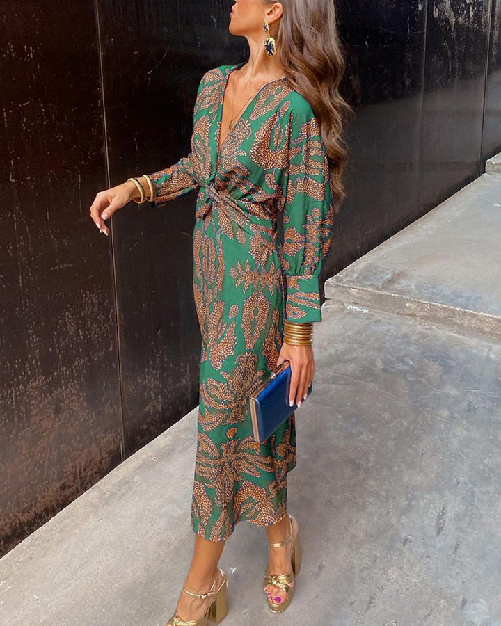 Woman in a flowing printed maxi dress with a flattering A-line silhouette on a plain background.
