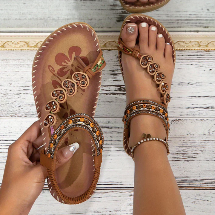 Female wearing stylish open-toe sandals on a plain background.