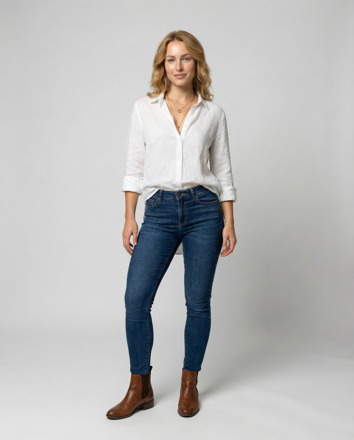 Woman showcasing a stylish V-neck blouse with elegant detailing on a plain background.
