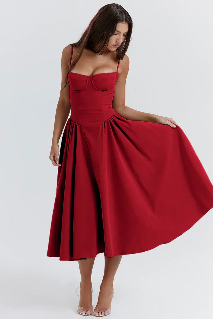 Woman wearing a feminine sleeveless midi dress on a plain background