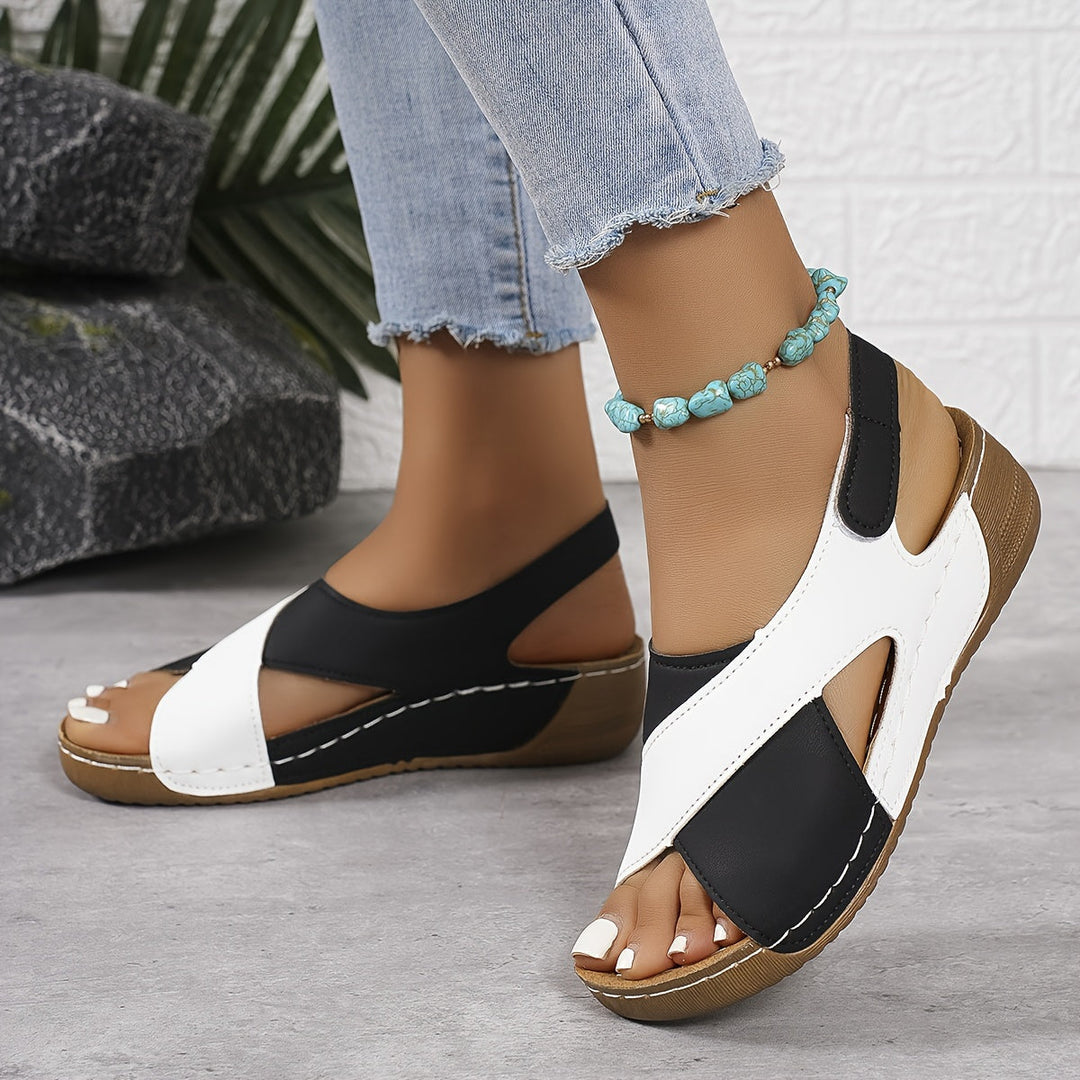 Female model wearing open toe walking sandals on a plain background