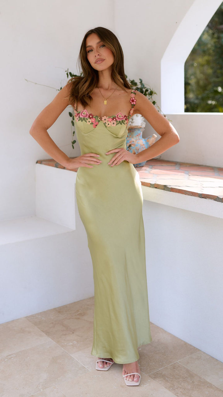 Model slight turn wearing floral maxi dress plain background