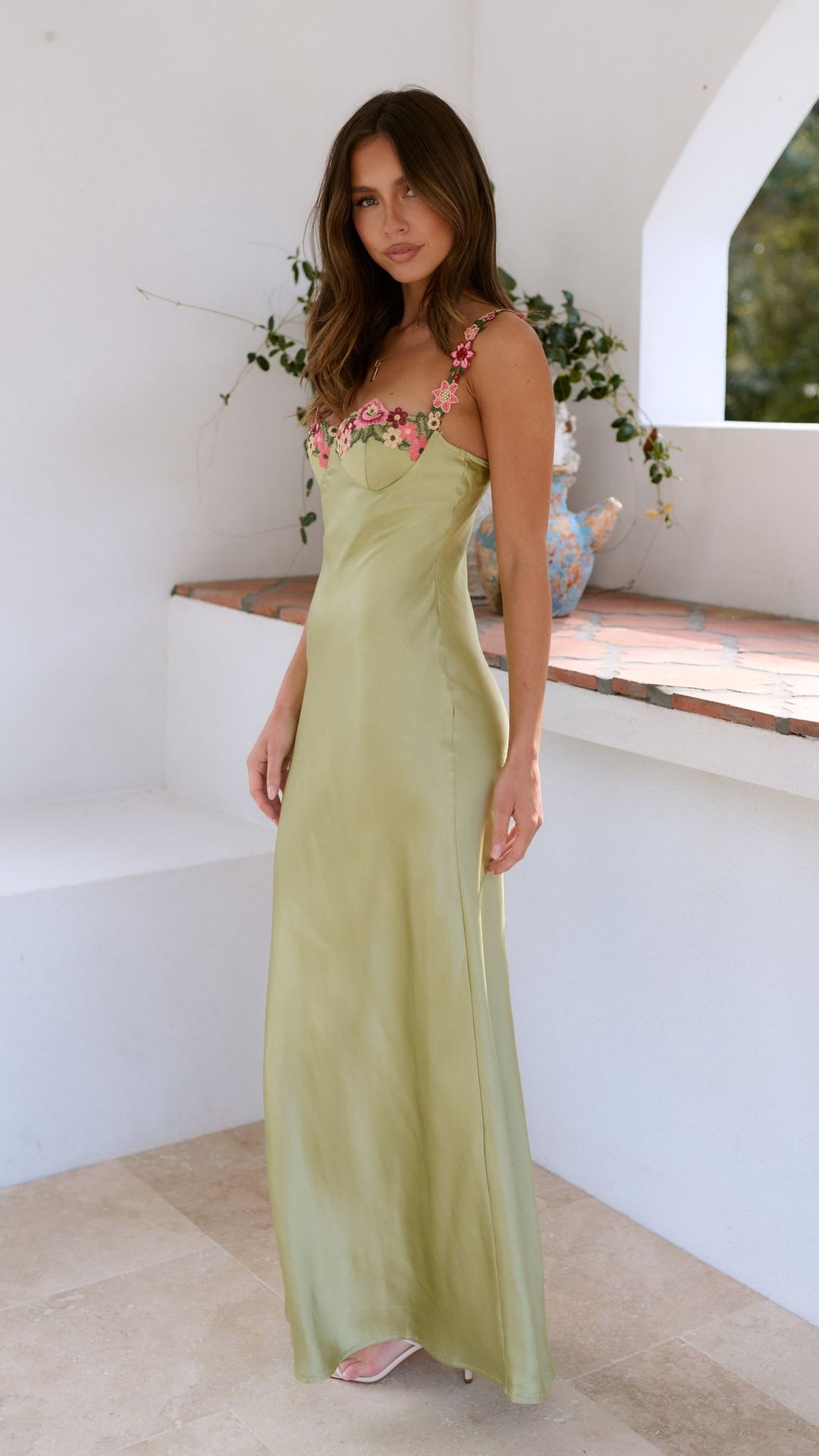 Model posing front angle long floral dress plain background