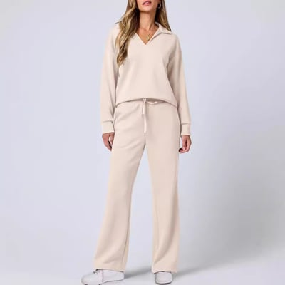 Female model wearing a modern jogging suit set against a plain background.