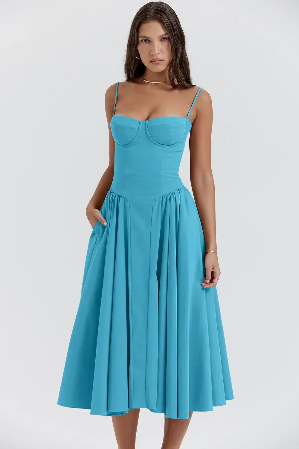 Woman wearing a softly draped dress against a plain background