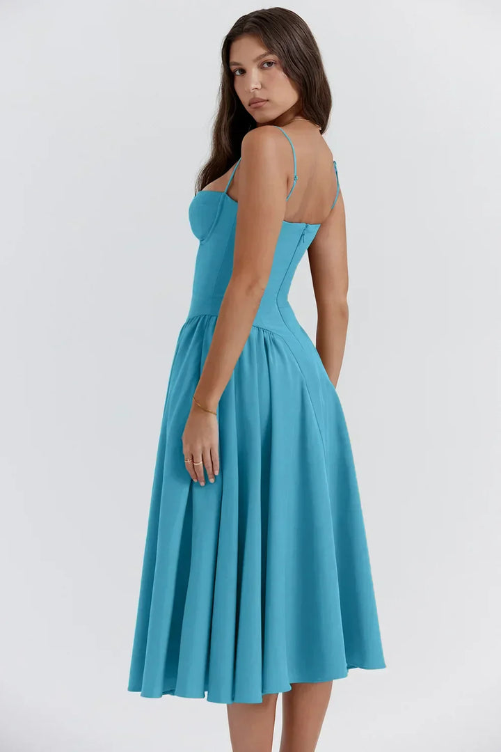 Female posing in a modern sleeveless midi dress on a plain background