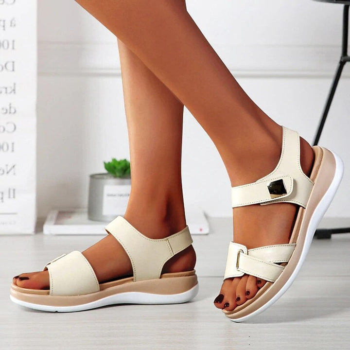 Foot model standing wearing sandals top view gray floor background