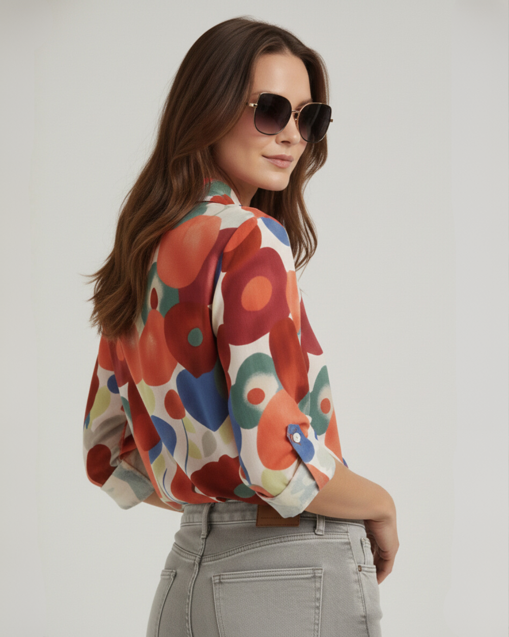 Model in sunglasses in back angled view of vibrant printed summer shirt 